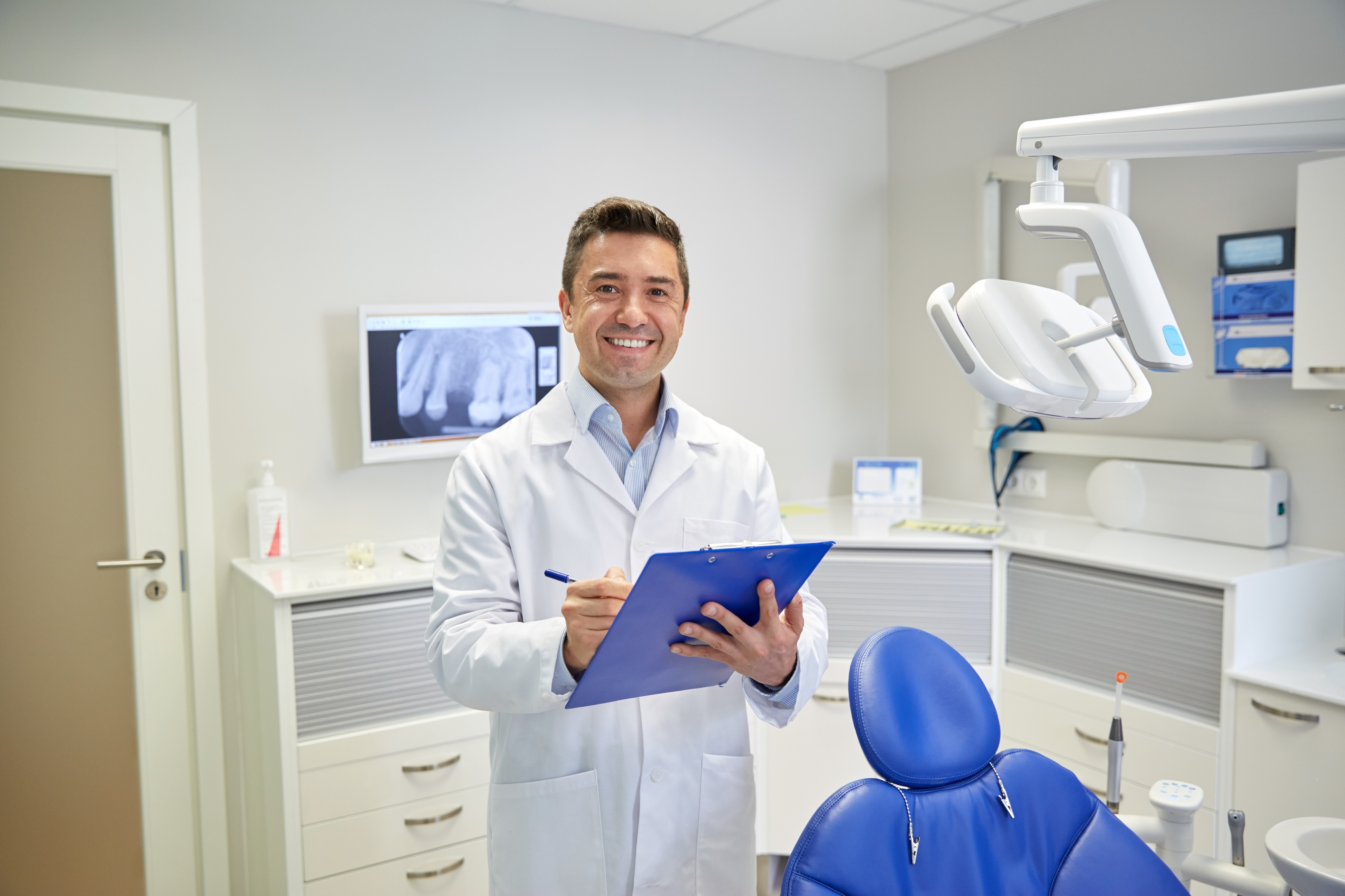 Dental professional completing OSHA documentation in a treatment room