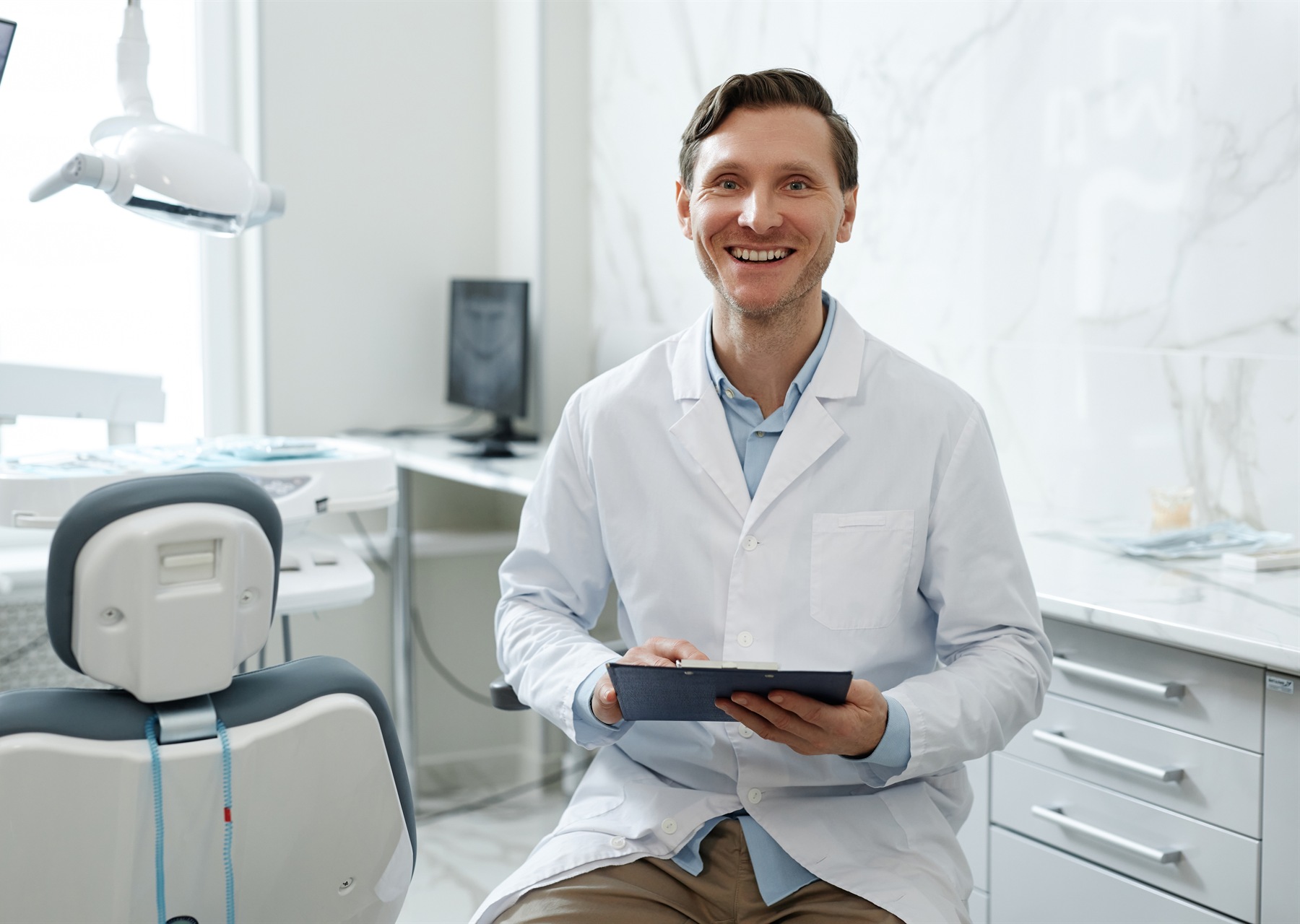 Smiling dental professional in a bright treatment room